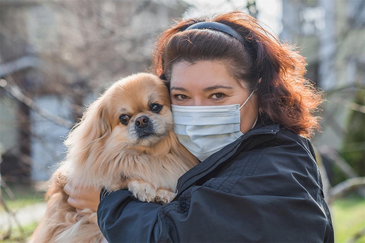 Mature Woman in mask with his pet on street because of air pollution 